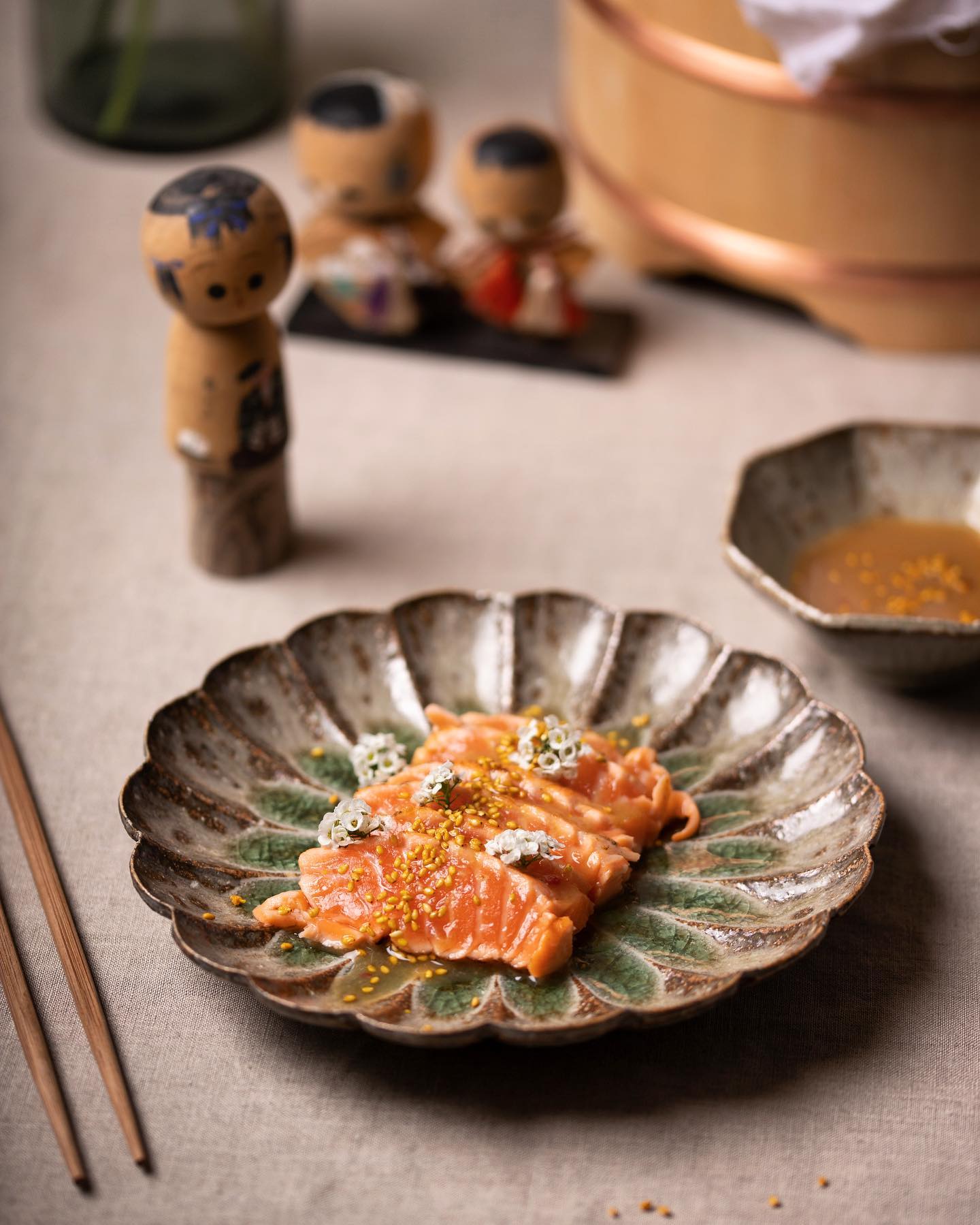 Saumon mariné, sésame doré et fleurs sur une assiette chrysanthème