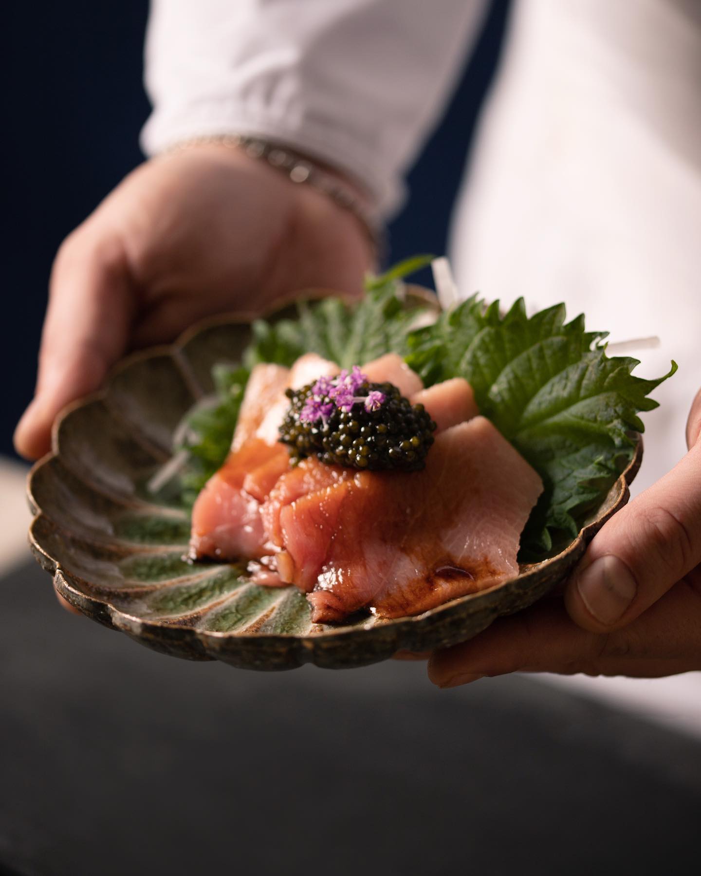 Sériole, caviar et shiso servis à la main sur une petite céramique