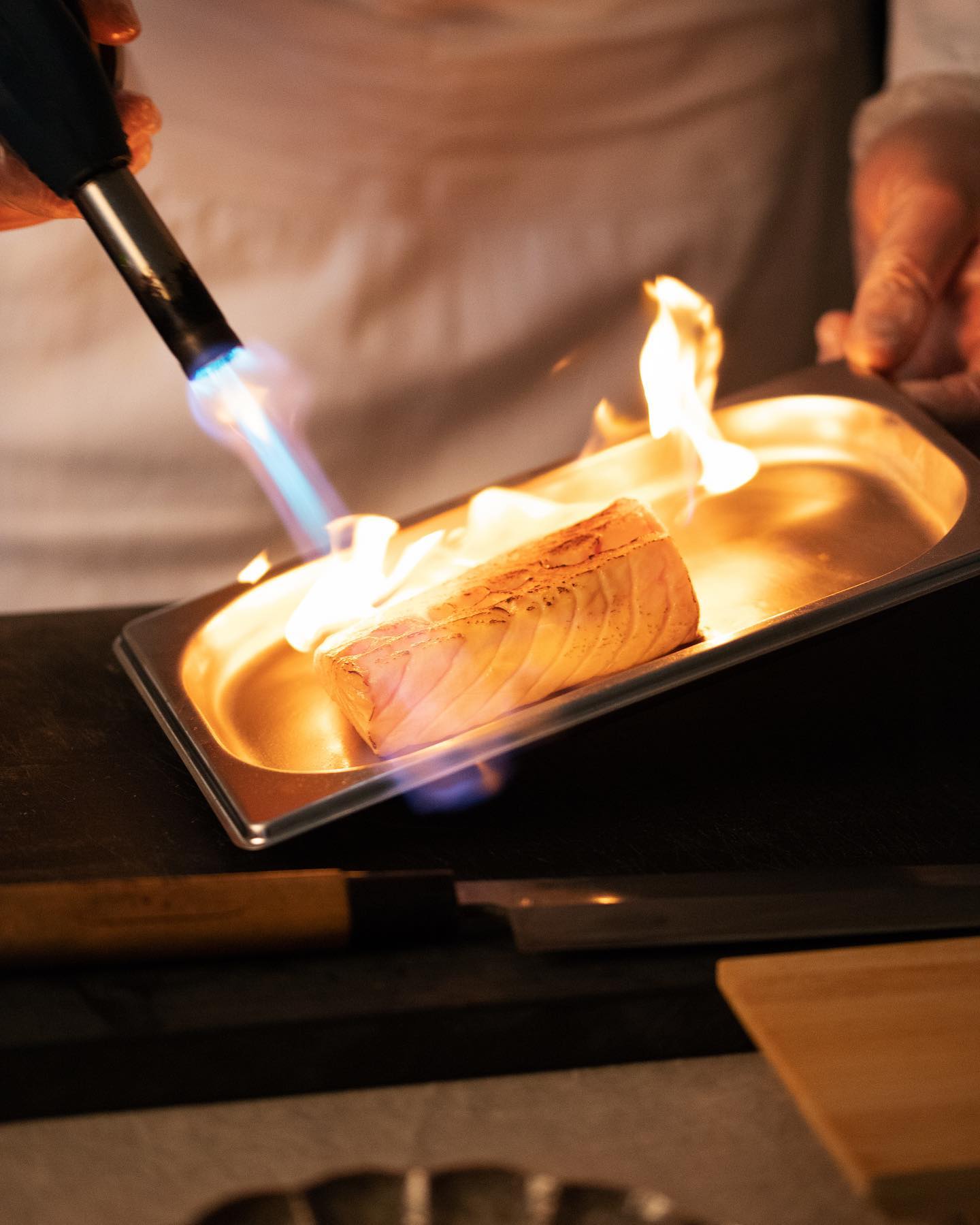 Filet de poisson flambé au chalumeau derrière le comptoir