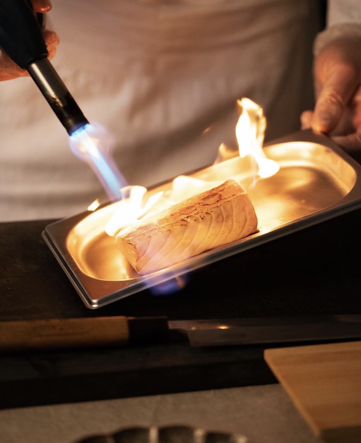 Saumon saisi au chalumeau pendant une prestation de chef à domicile
