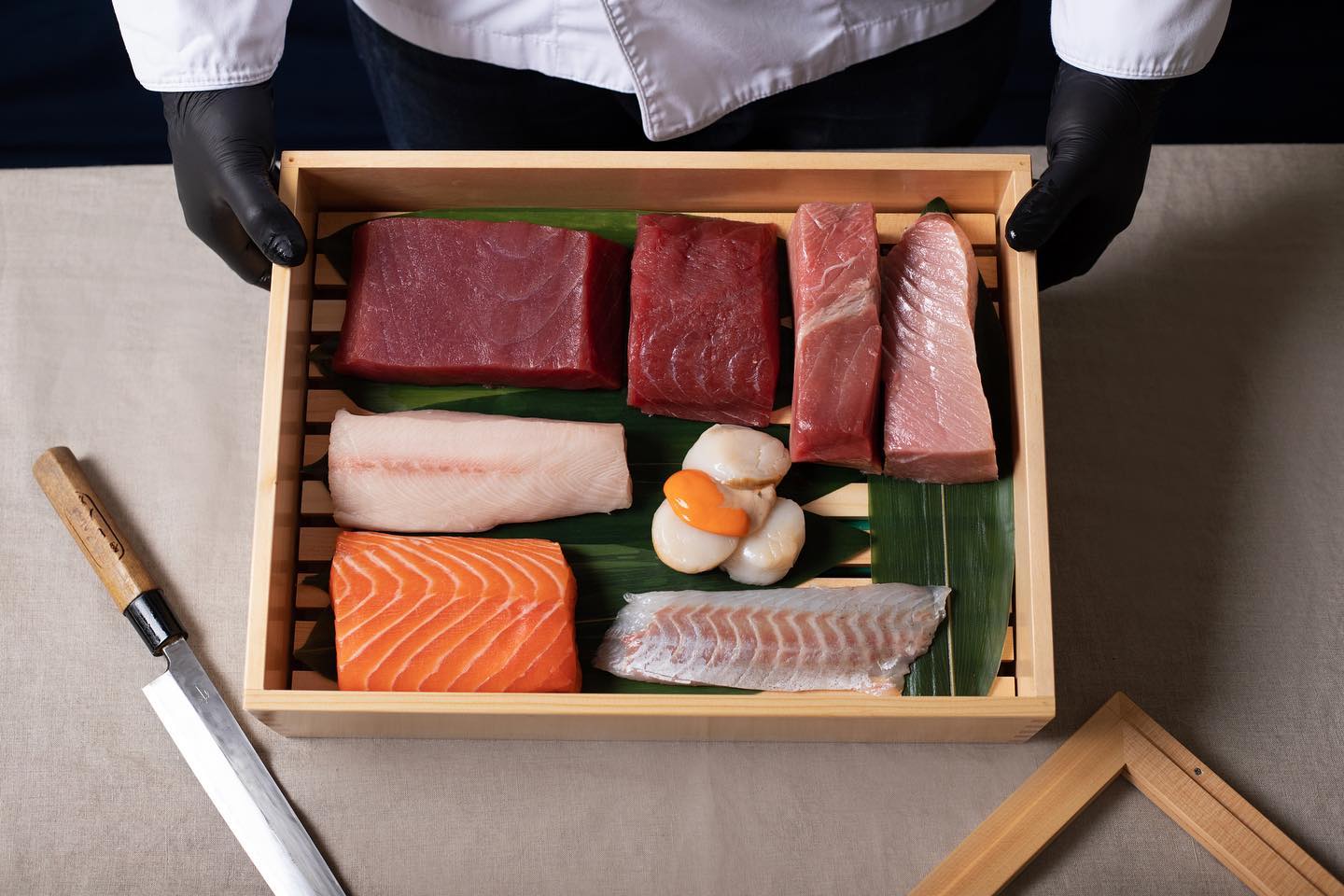 Le chef présente sa caisse de poissons : thon rouge, toro, saumon, saint-jacques