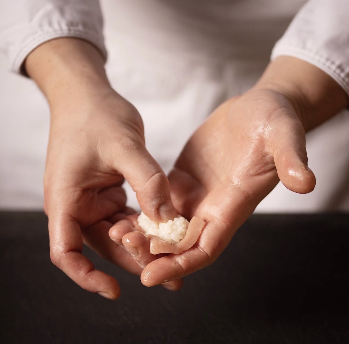 Les mains du chef façonnant un nigiri